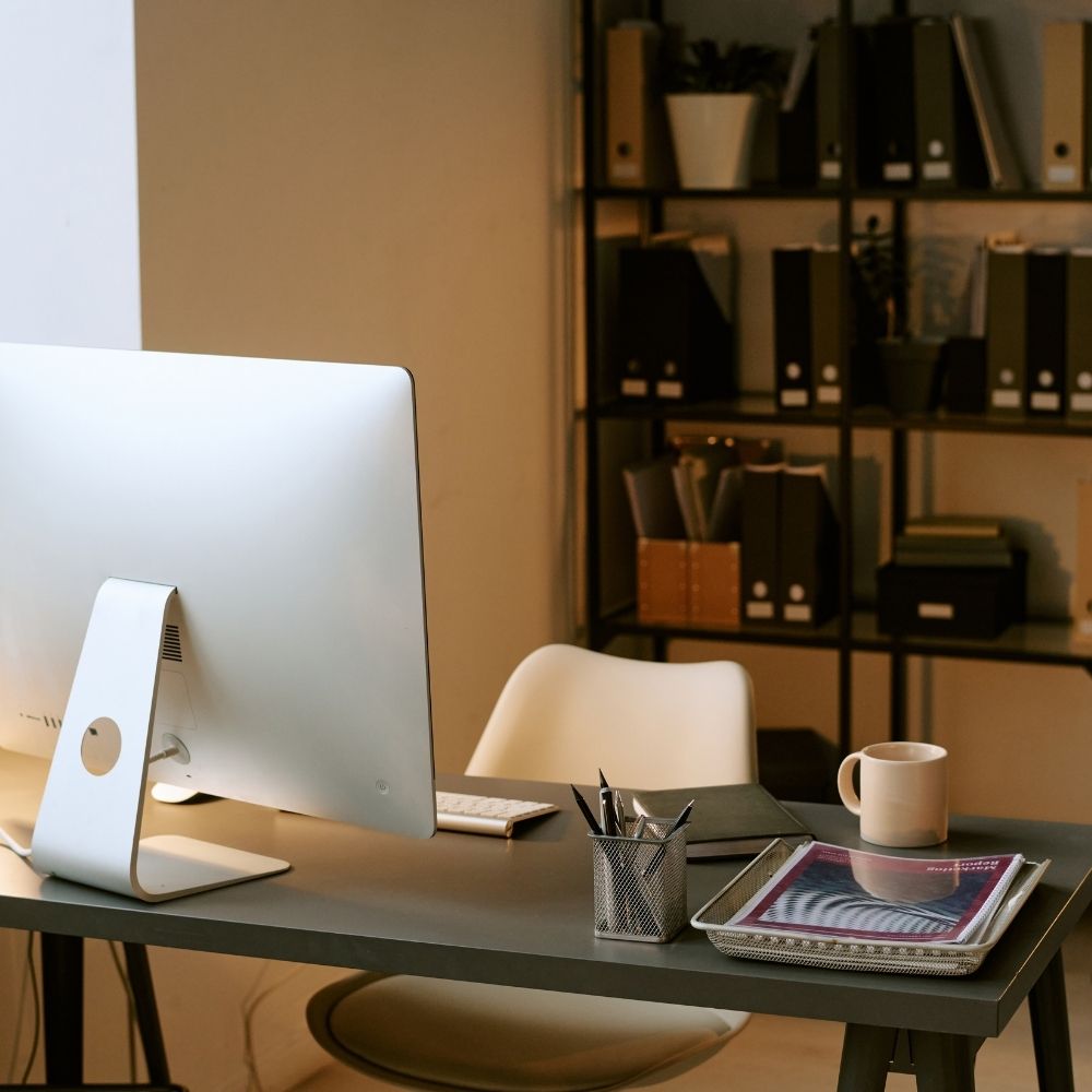 Mesa de trabalho com monitor e objetos de escritório